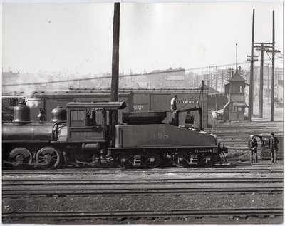 Locomotiva a vapore e vagoni ferroviari in un deposito ferroviario non identificato da Charles Clement Holt